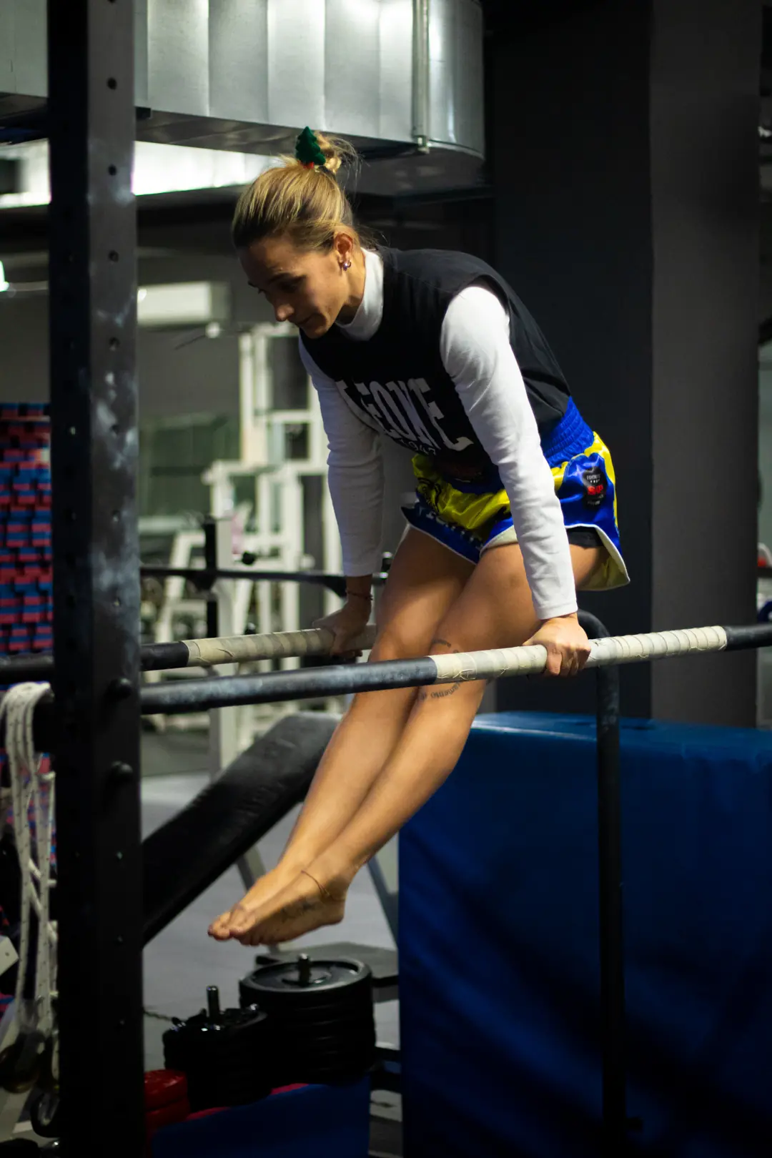 Allieva in sospensione alle parallele durante il calisthenics