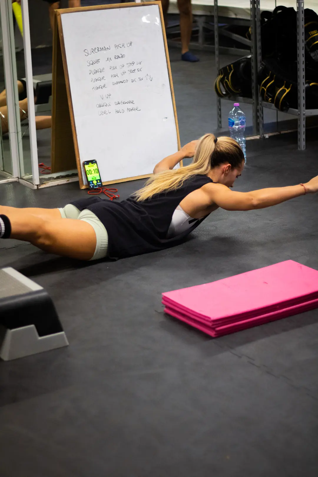 Allieva esegue il superman sul tappeto durante il functional training