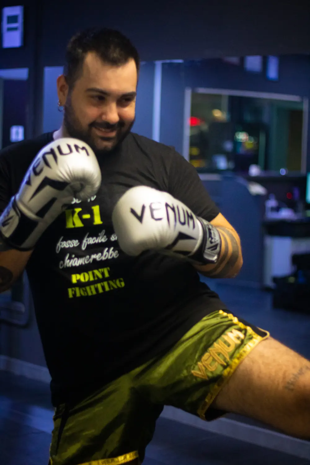 Allievo amatore di kickboxing sorride in guardia durante la lezione