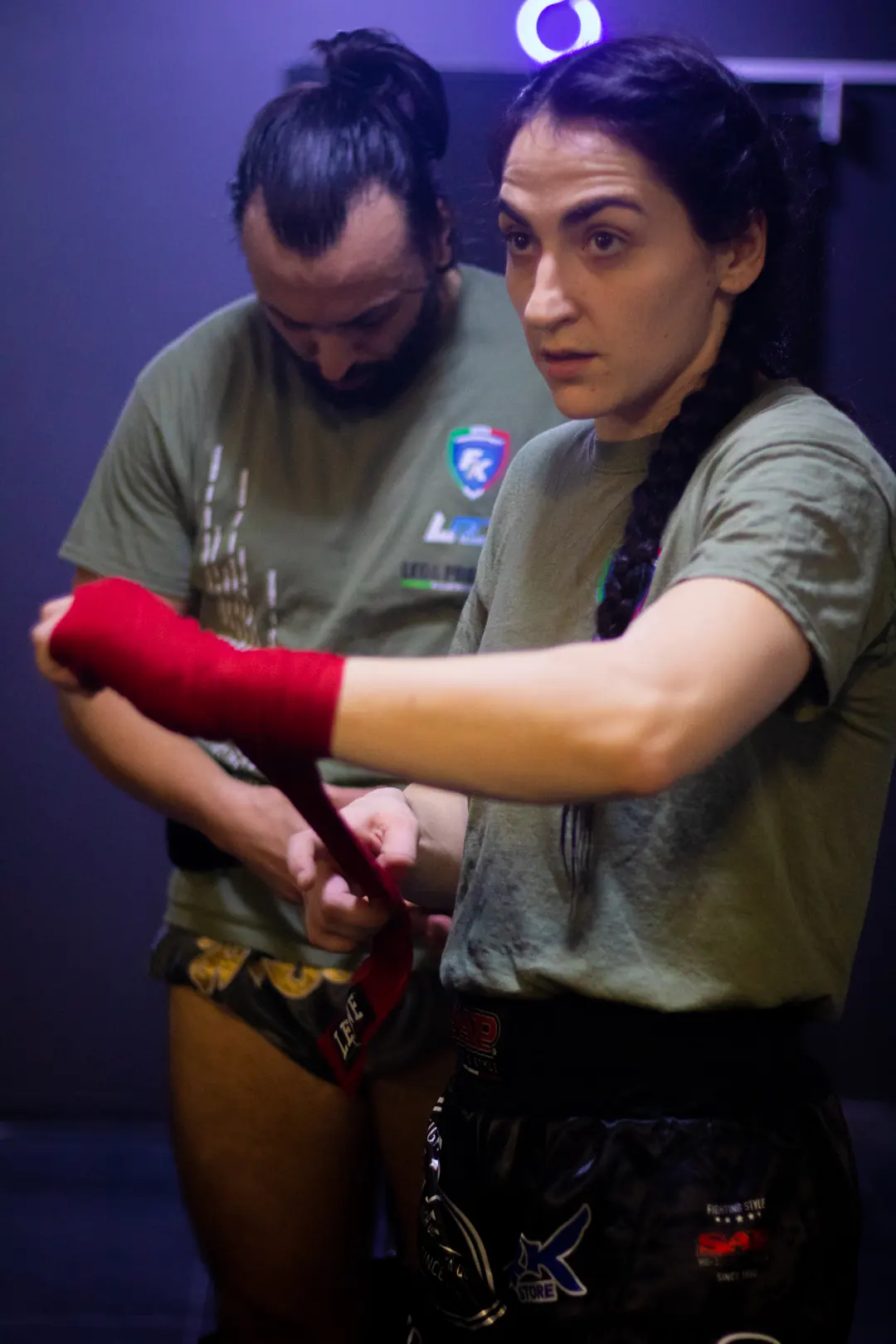 Atleta si mette le fasce rosse prima dell'allenamento di kickboxing