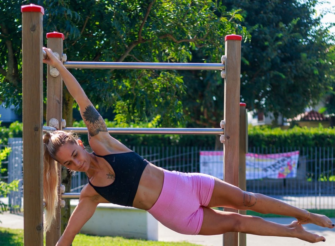 Yvonne Rivellini esegue una human flag su una struttura di calisthenics all&rsquo;aperto
